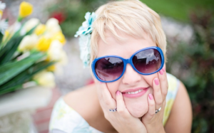 woman with sunglasses touching face